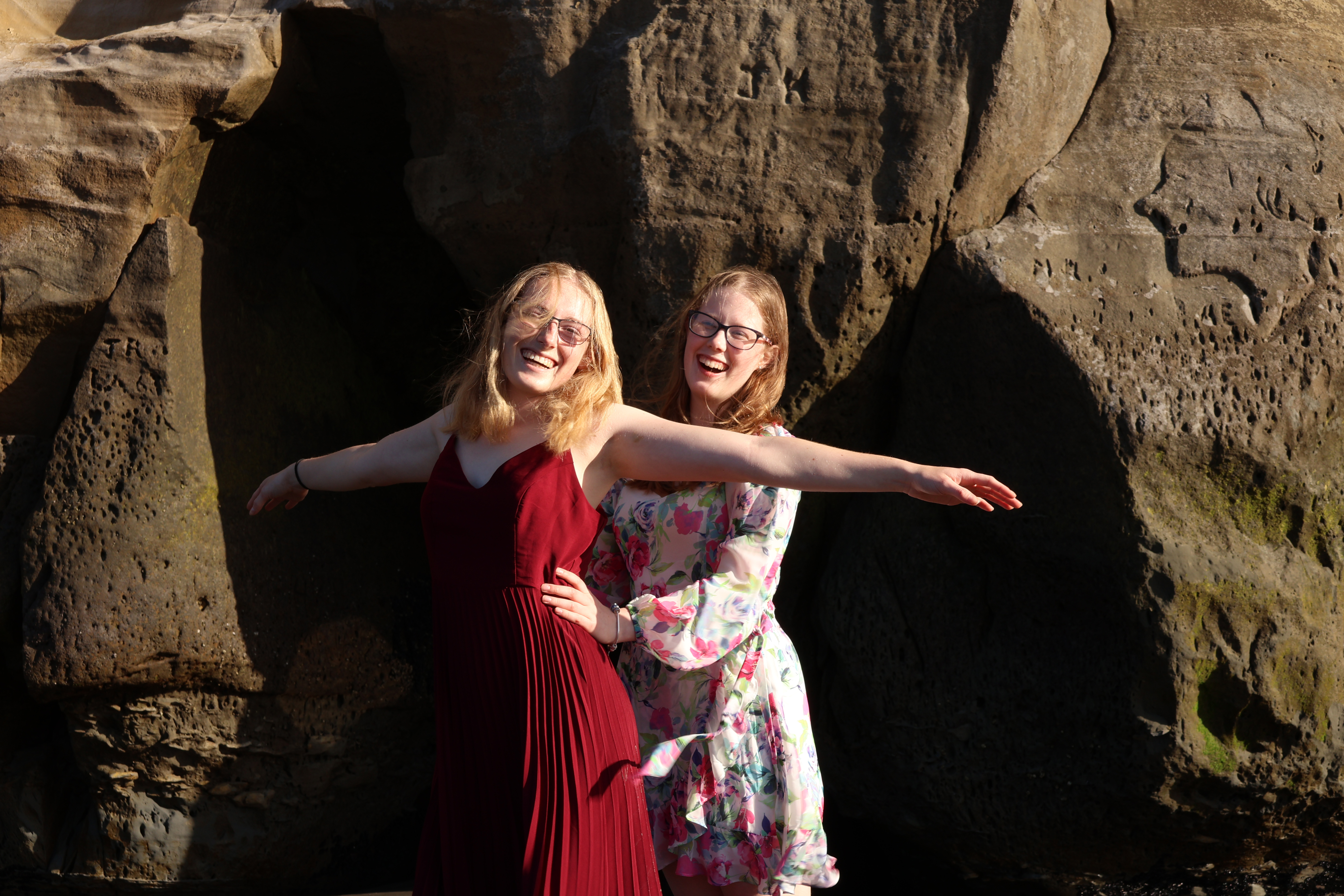2 girls laughing on a beach